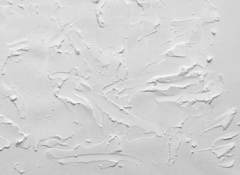 Enduit blanc au relief marqué, en lumière rasante