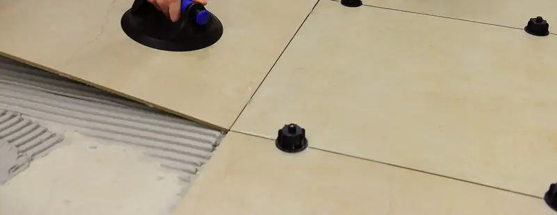 Grand carreau clair posé à la ventouse, cales de nivellement entre les joints