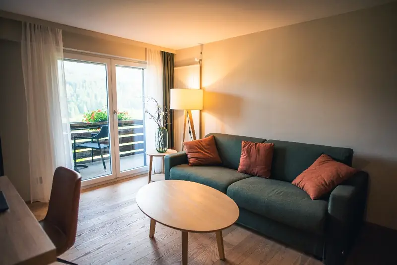 Salon au parquet clair, lumière douce d’une baie vitrée